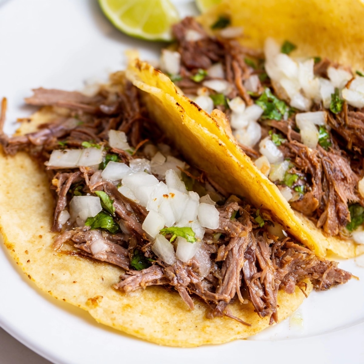 Juicy Crock Pot Carne Asada Street Tacos filling overflowing from warm, butter-fried mini tortillas.