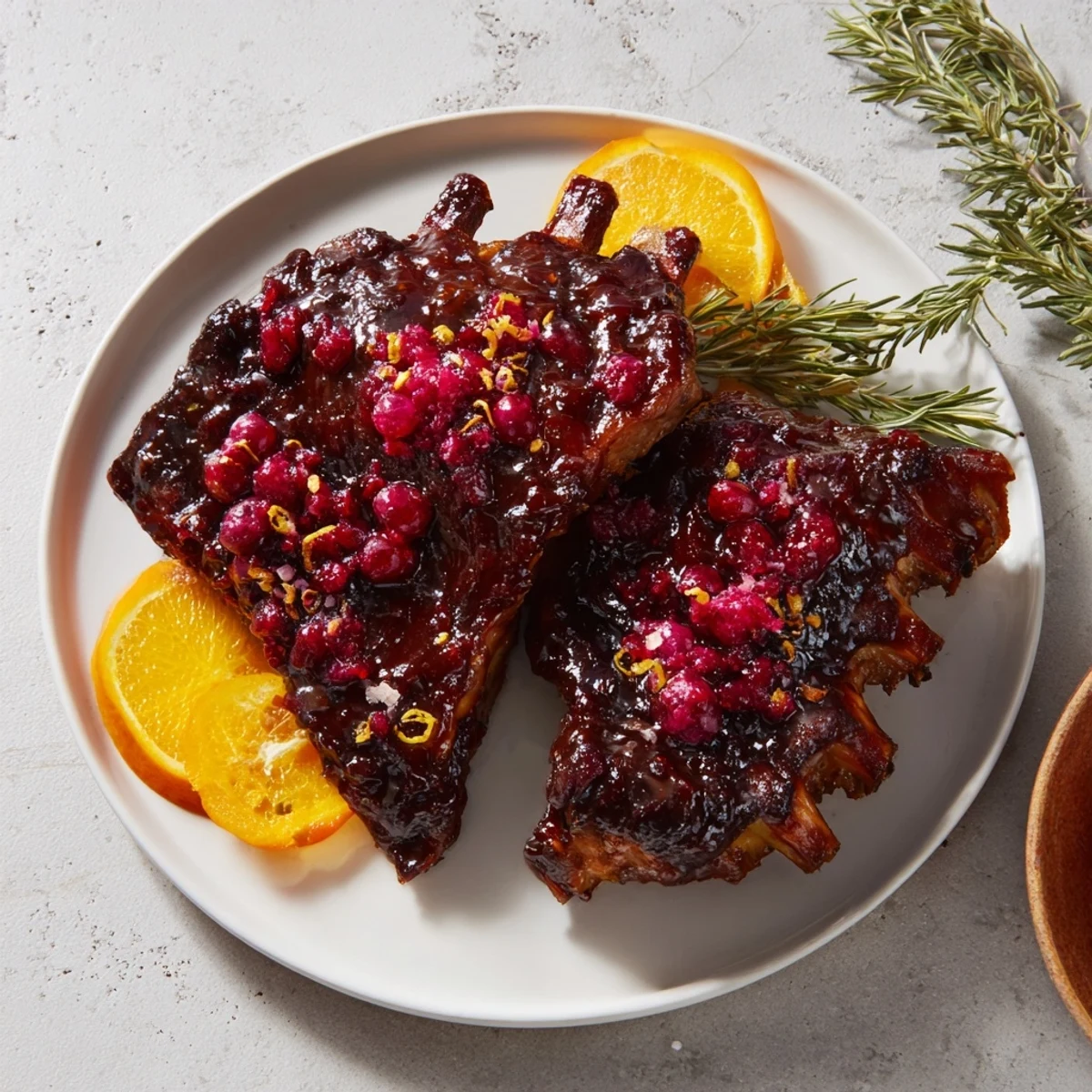 Golden-brown Cranberry Orange Glazed Turkey Breast, served with vibrant orange slices and rosemary sprigs for serving.