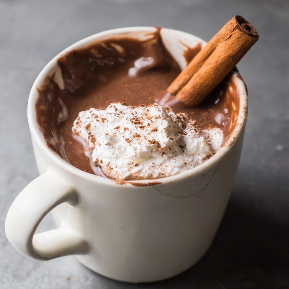 Deeply flavored Spiced Hot Chocolate, ready to be sipped with a fragrant cinnamon stick for stirring.