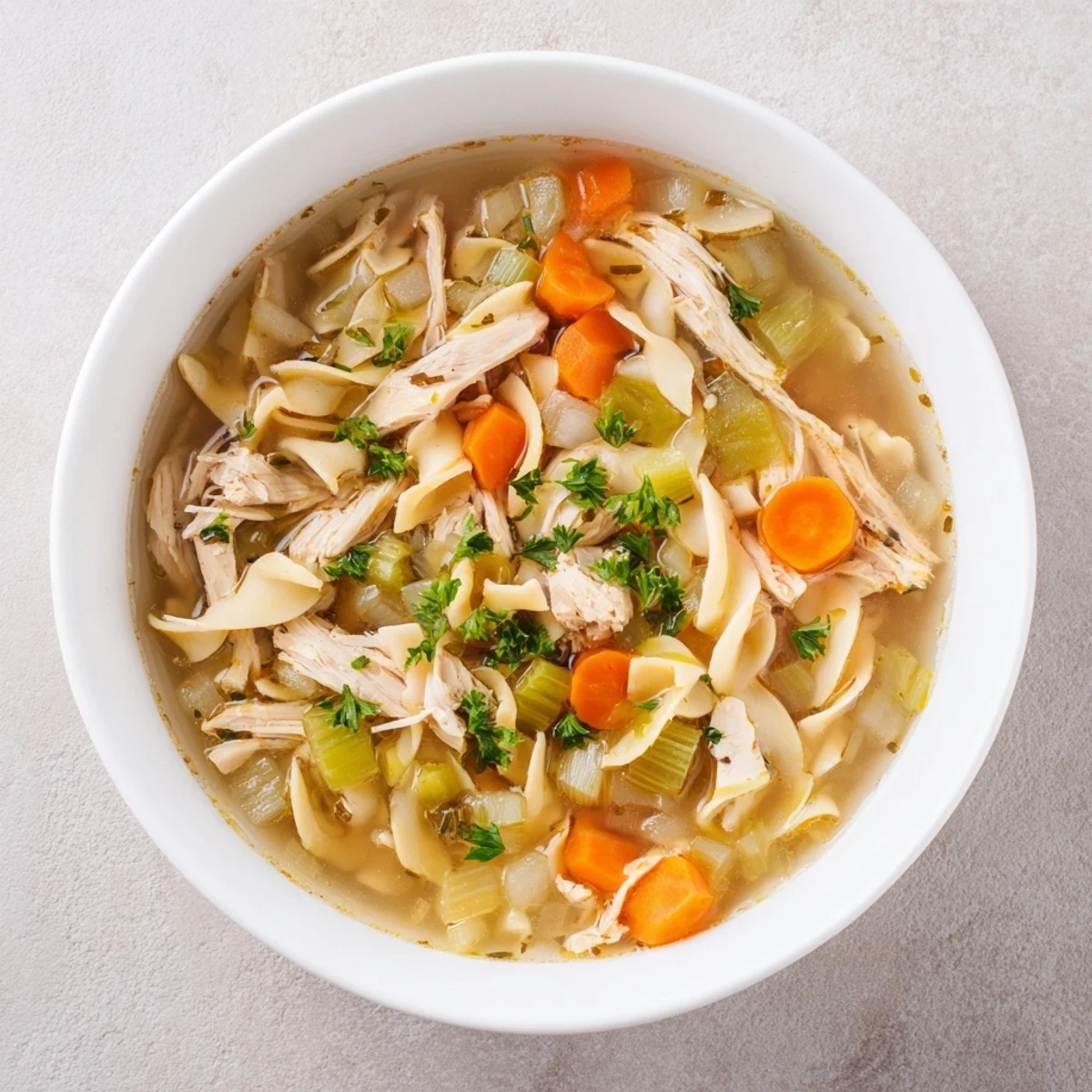 Golden-broth Savory Chicken Noodle Soup with vibrant veggies and tender, shredded chicken pieces.