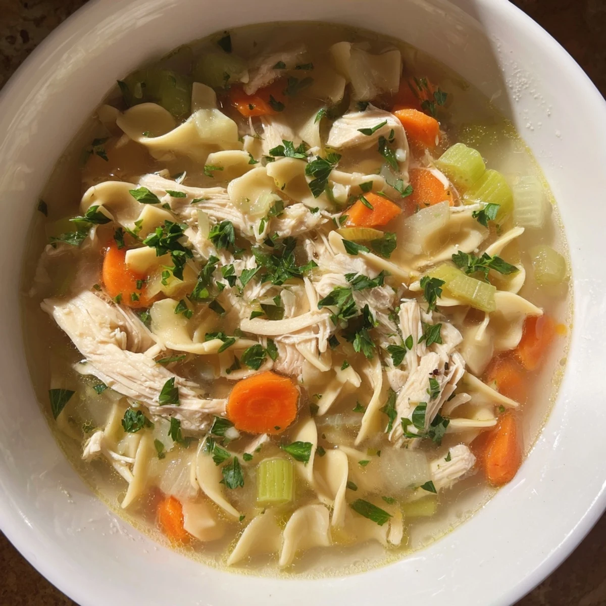 Warm, comforting bowl of Savory Chicken Noodle Soup, ready to serve with fresh parsley garnish.