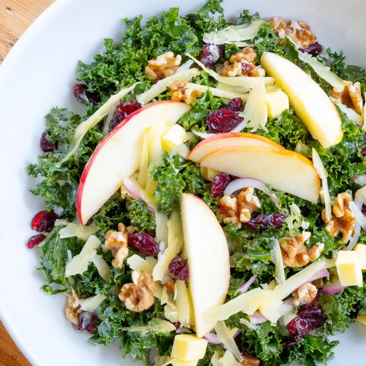 Close-up of a vibrant Winter Kale Salad, featuring crisp apples and sharp cheddar, perfect for fall.