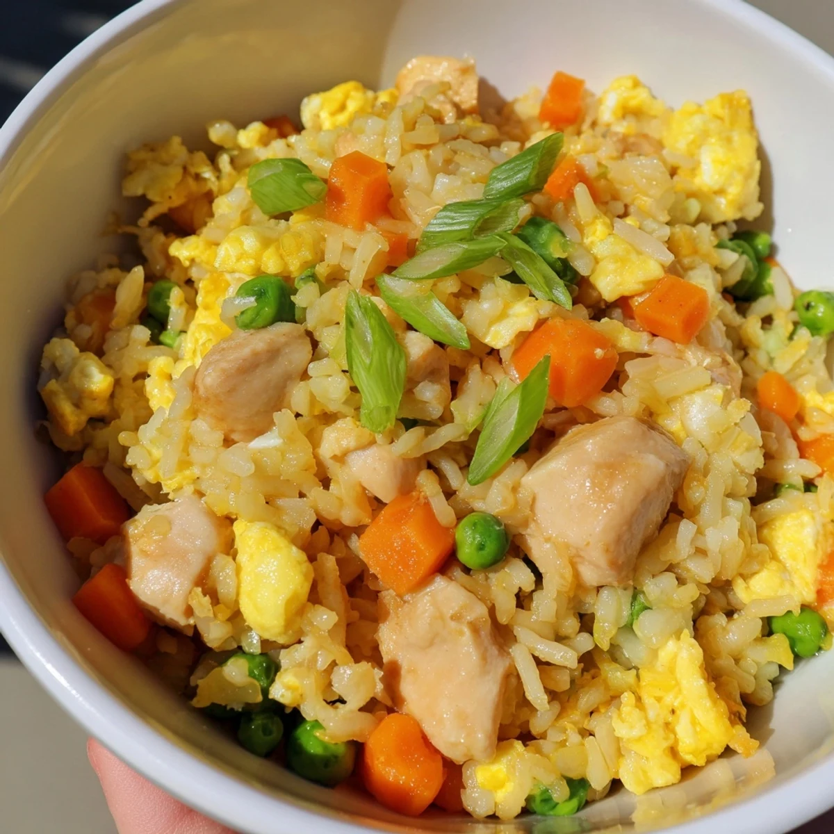 Close-up of Chicken Fried Rice, featuring tender chicken cubes and colorful diced carrots mixed in steaming rice.