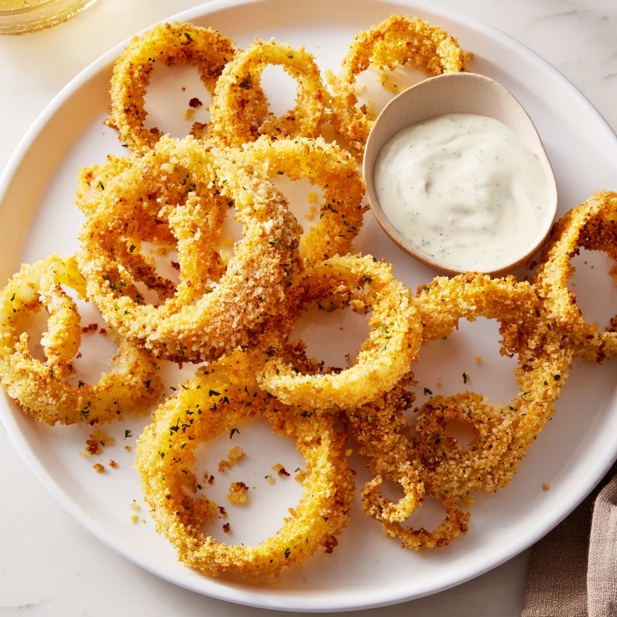 Crispy Baked Onion Rings with Ranch Dressing are golden and crunchy, served hot from the oven on a rustic platter.
