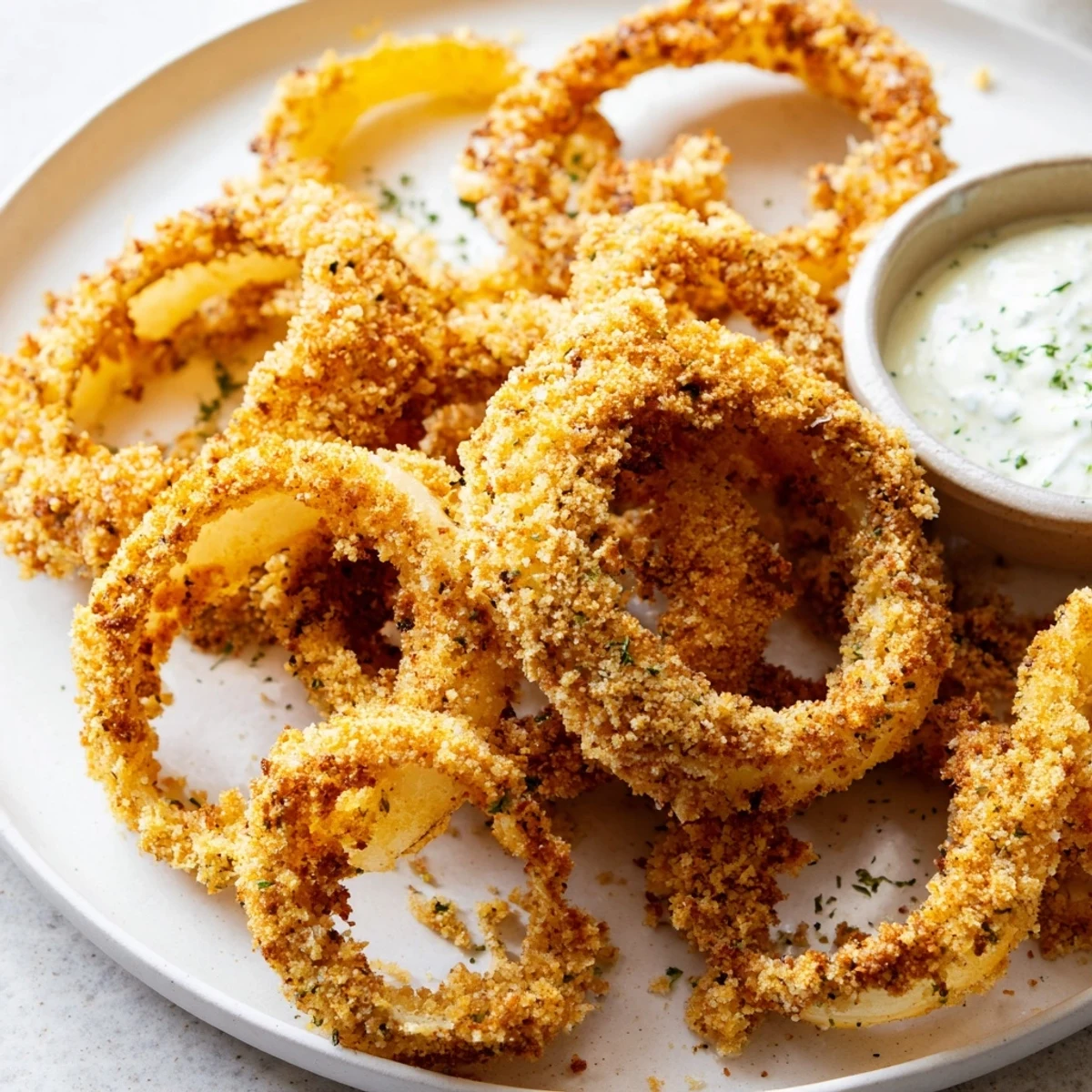 A platter of Crispy Baked Onion Rings with Ranch Dressing, showing the golden crunch, served with a side of ranch.