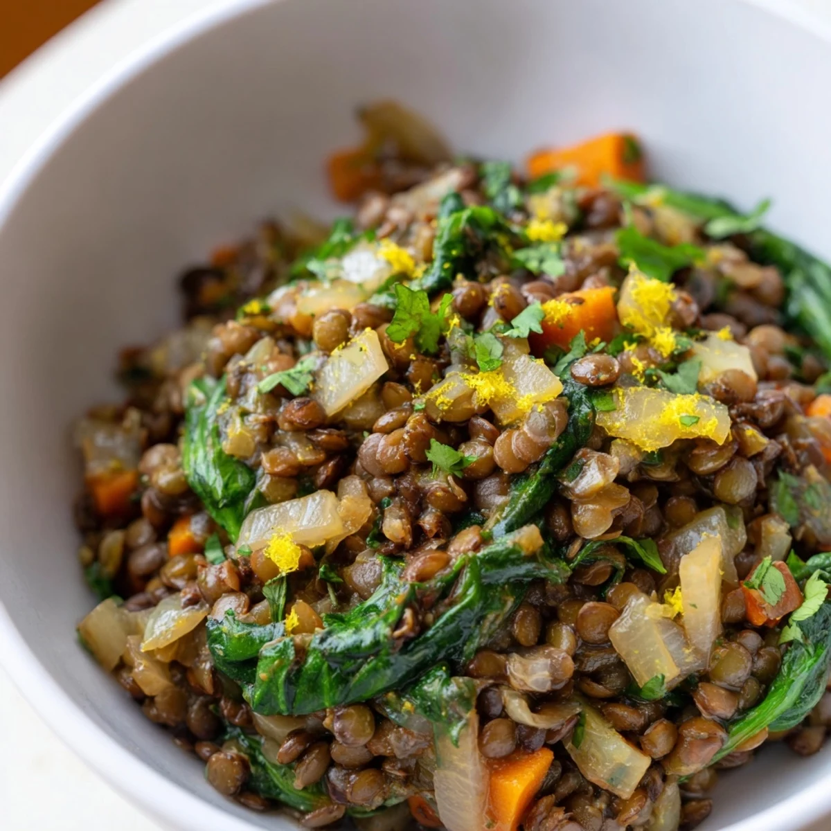 Steaming bowl of Spiced Lentil and Spinach Stew with Lemon, garnished with fresh cilantro and a lemon wedge.