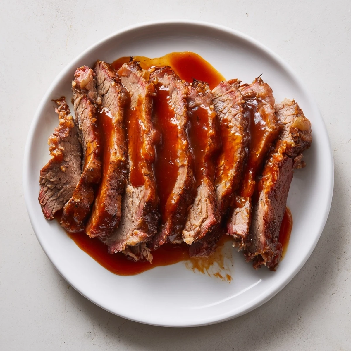 Slow Cooked Beef Brisket with Smoky BBQ Sauce, sliced thick and glistening with rich barbecue glaze on a wooden board.