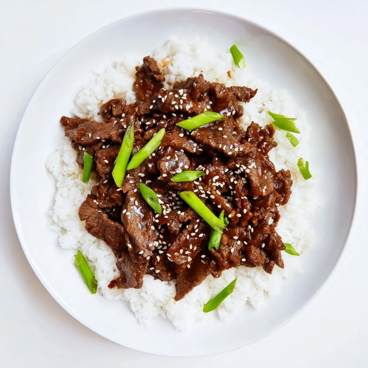 Crockpot with Ultimate Slow Cooker Mongolian Beef served over rice, featuring tender beef slices coated in savory-sweet sauce.