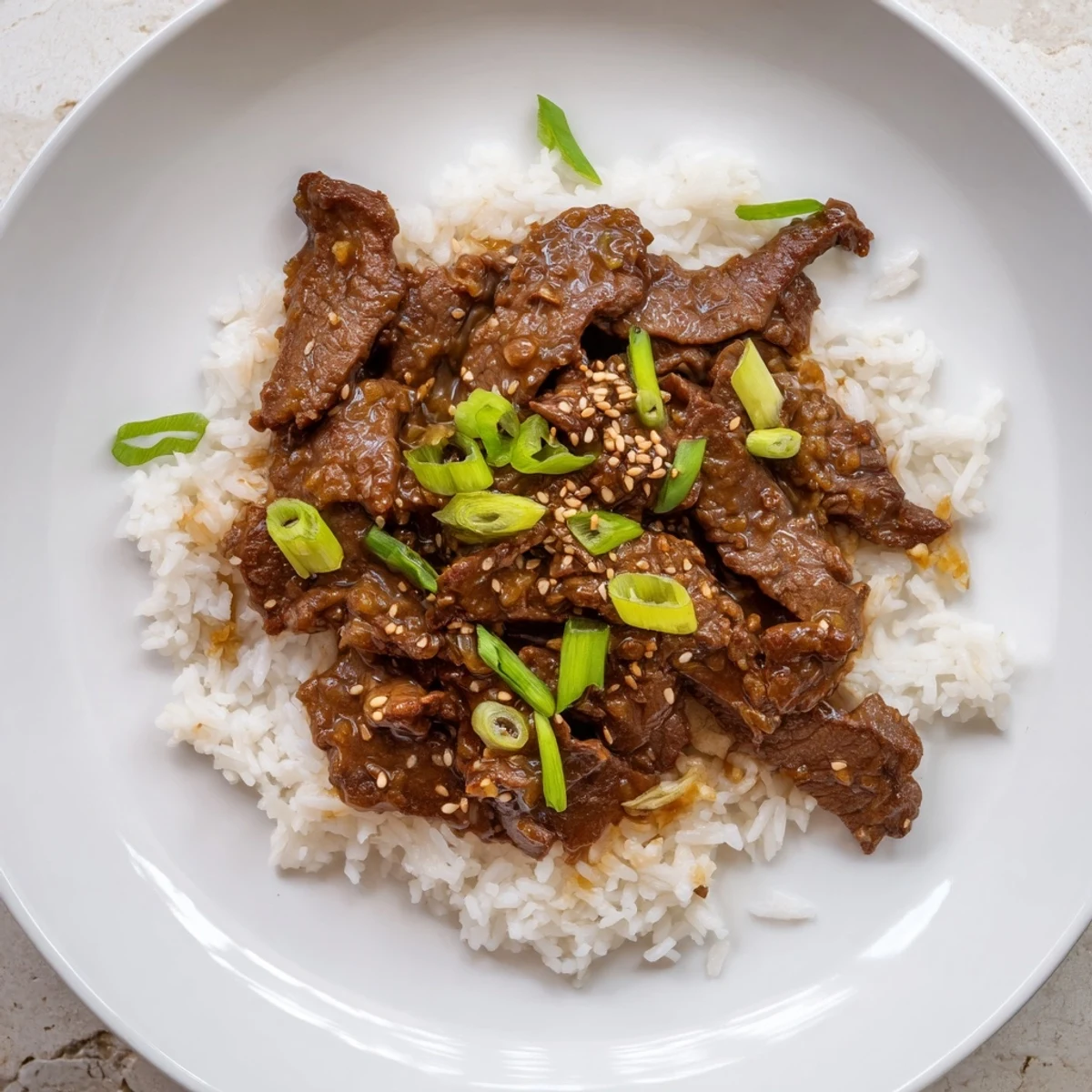 Ultimate Slow Cooker Mongolian Beef plated with steamed rice and sesame seeds, a comforting Asian-inspired family dinner.