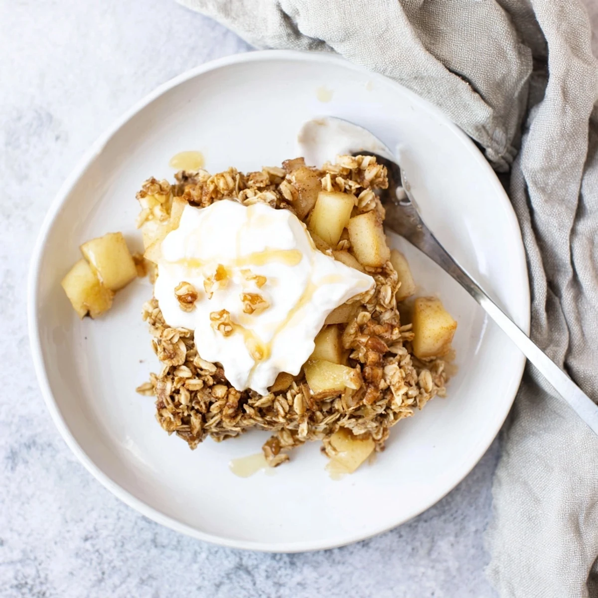 A close-up slice of Baked Apple Oatmeal With Greek Yogurt reveals juicy apples and tender oats in a cozy breakfast.