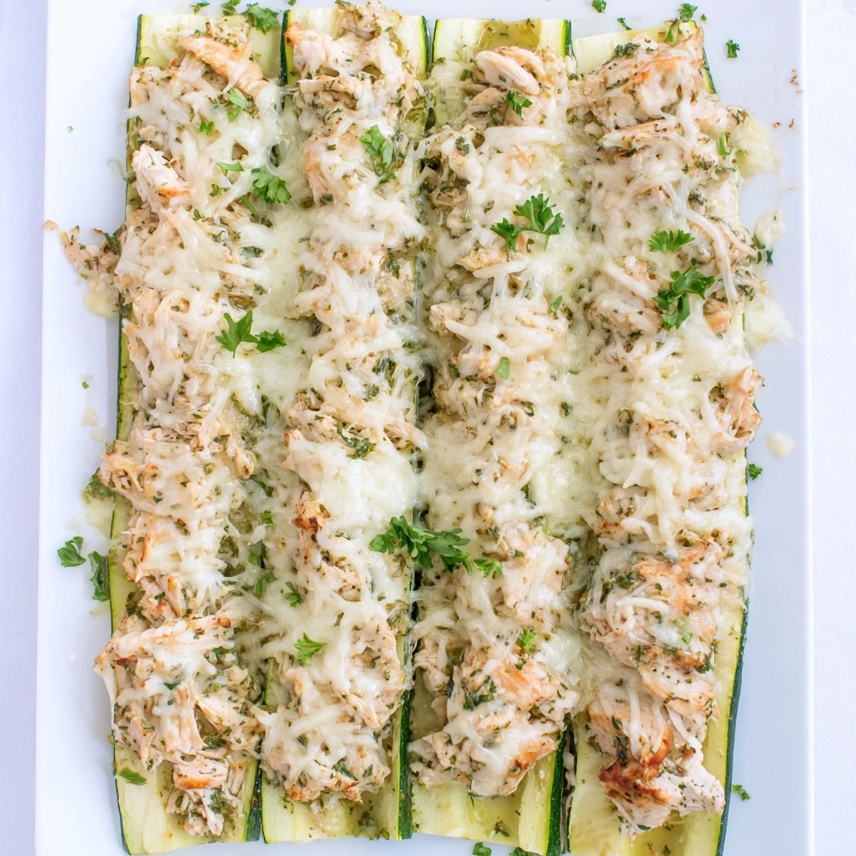 Golden-brown Chicken Alfredo Zucchini Lasagna served with a glass of white wine.