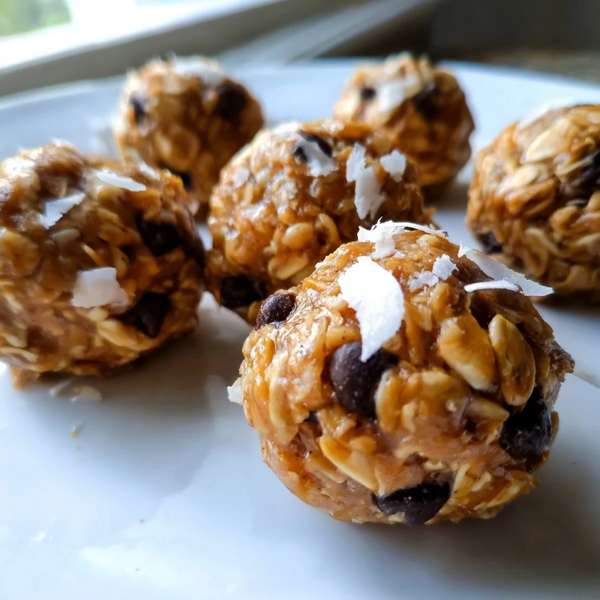 These gluten-free Easy No Bake Chocolate Chip Energy Bites are rolled in shredded coconut, perfect for a healthy grab-and-go snack.