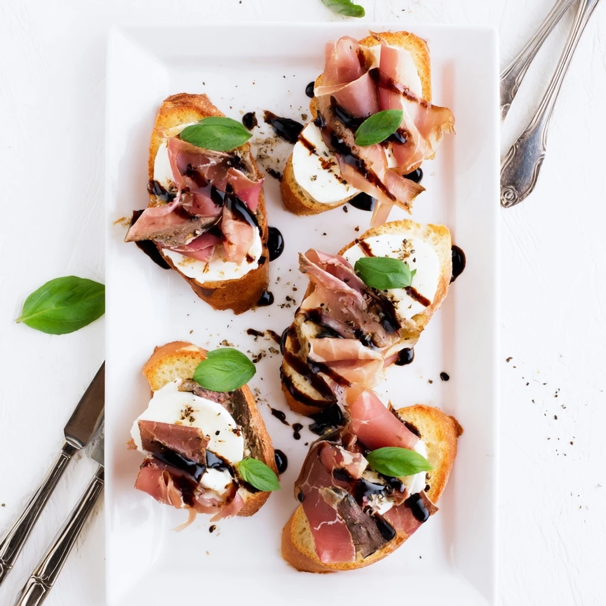 Golden-brown baguette slices topped with melted mozzarella and savory roast beef for Mozzarella Beef Prosciutto Crostini.