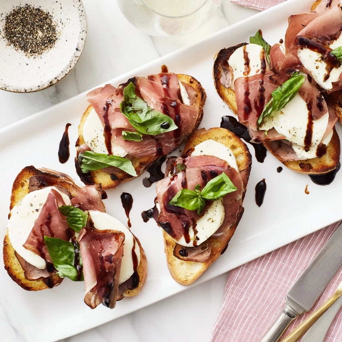 Warm Mozzarella Beef Prosciutto Crostini appetizer featuring crispy bread, creamy cheese, and elegant meat layers.