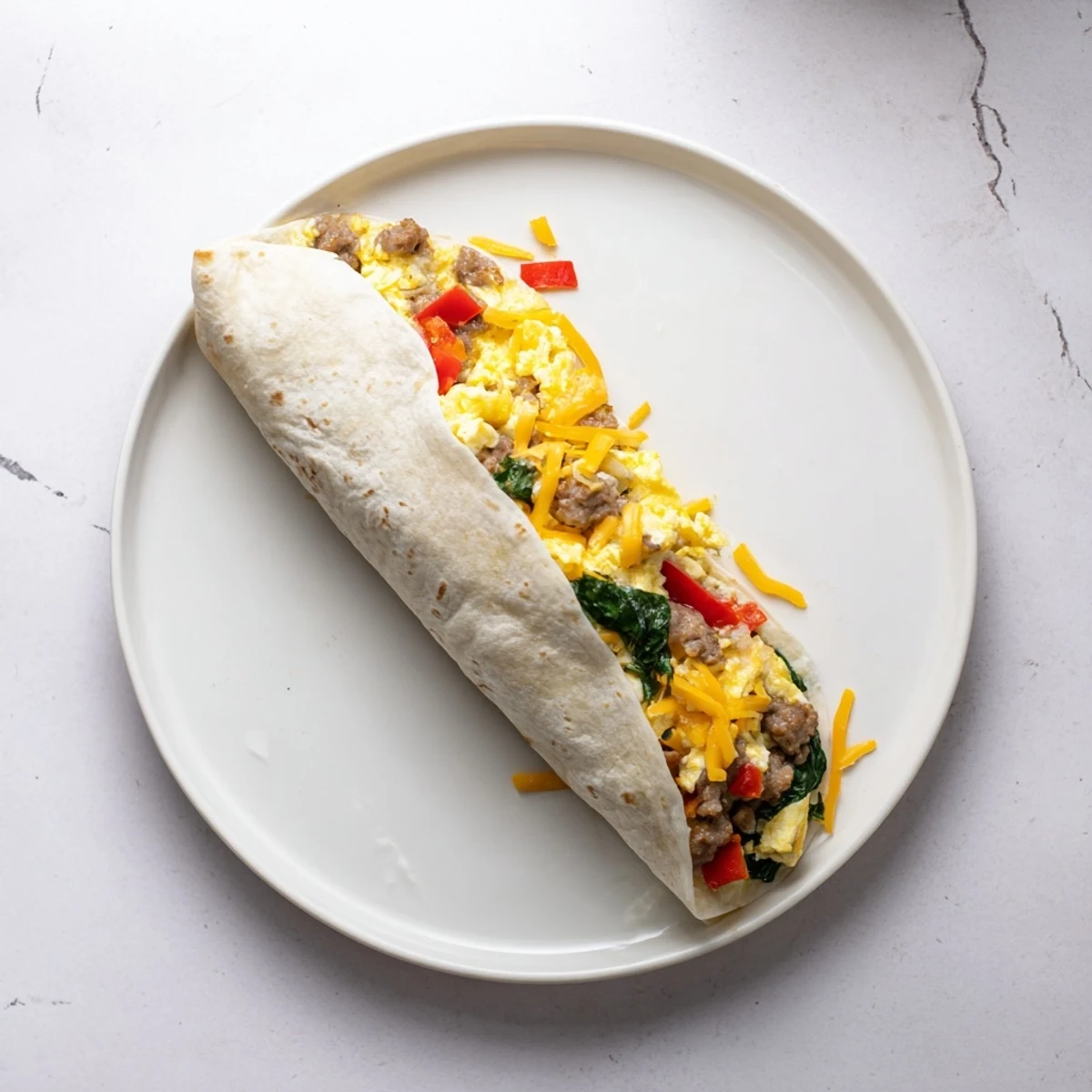 Savory Make-Ahead Breakfast Burritos filled with fluffy eggs, sausage, peppers, and cheese, served with salsa.