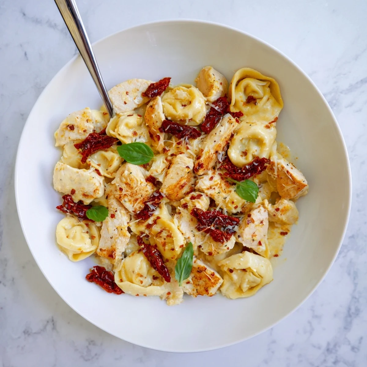 One-pan Marry Me Chicken Tortellini skillet garnished with fresh basil and extra parmesan