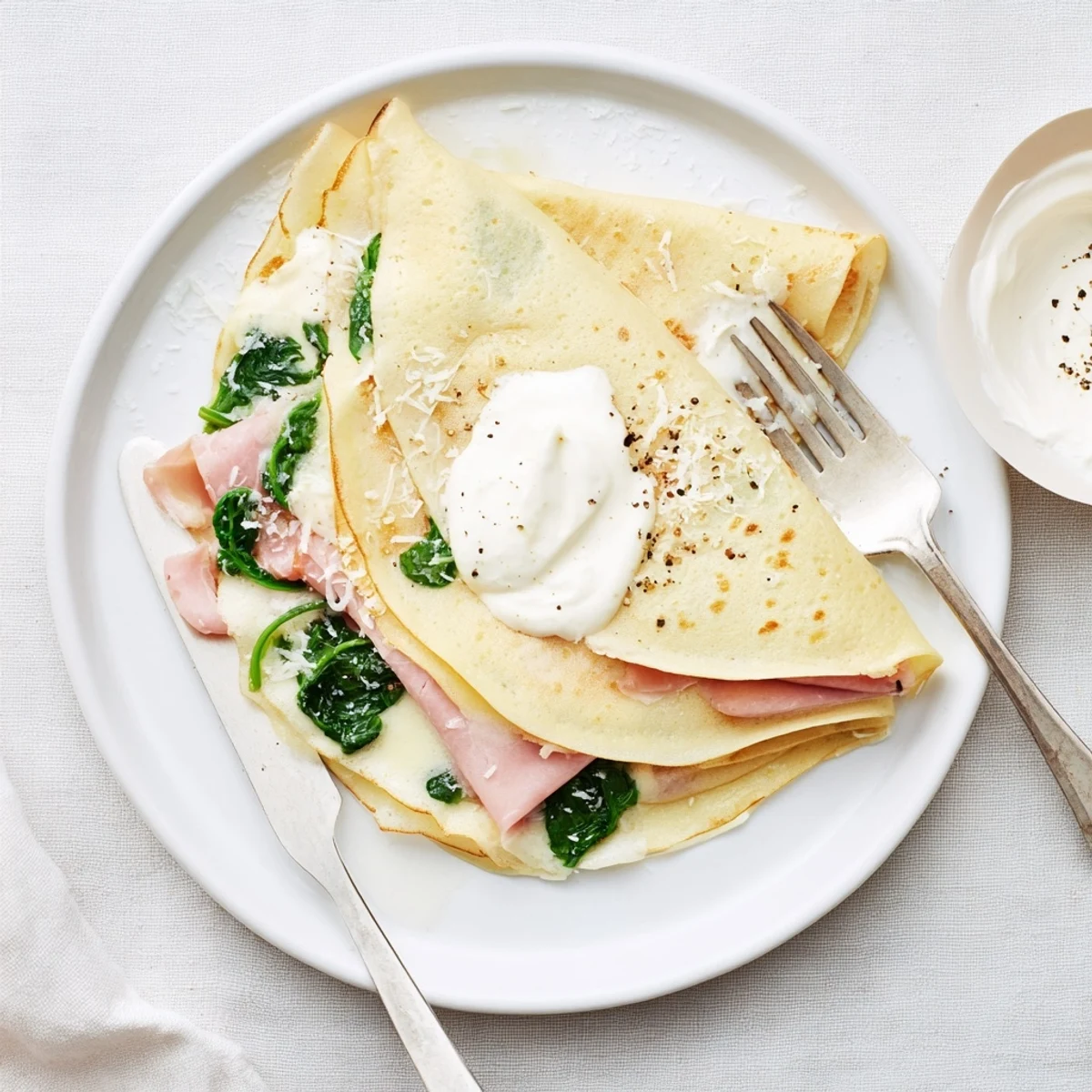 Delicate thin savory crepes rolled with cheese and spinach, baked until bubbly and golden.