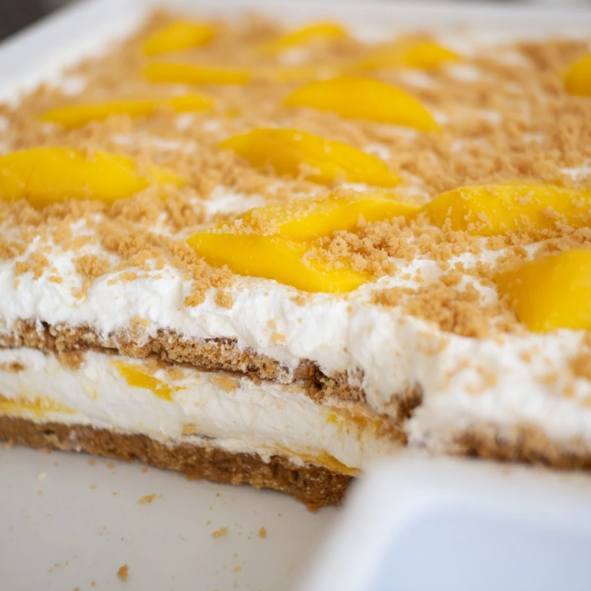Golden layers of Filipino Mango Float with ripe mango slices and whipped cream topping