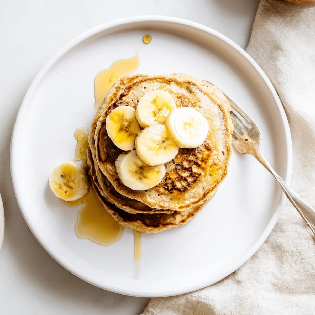 Steamy stack of Greek yogurt banana pancakes served with butter and berries