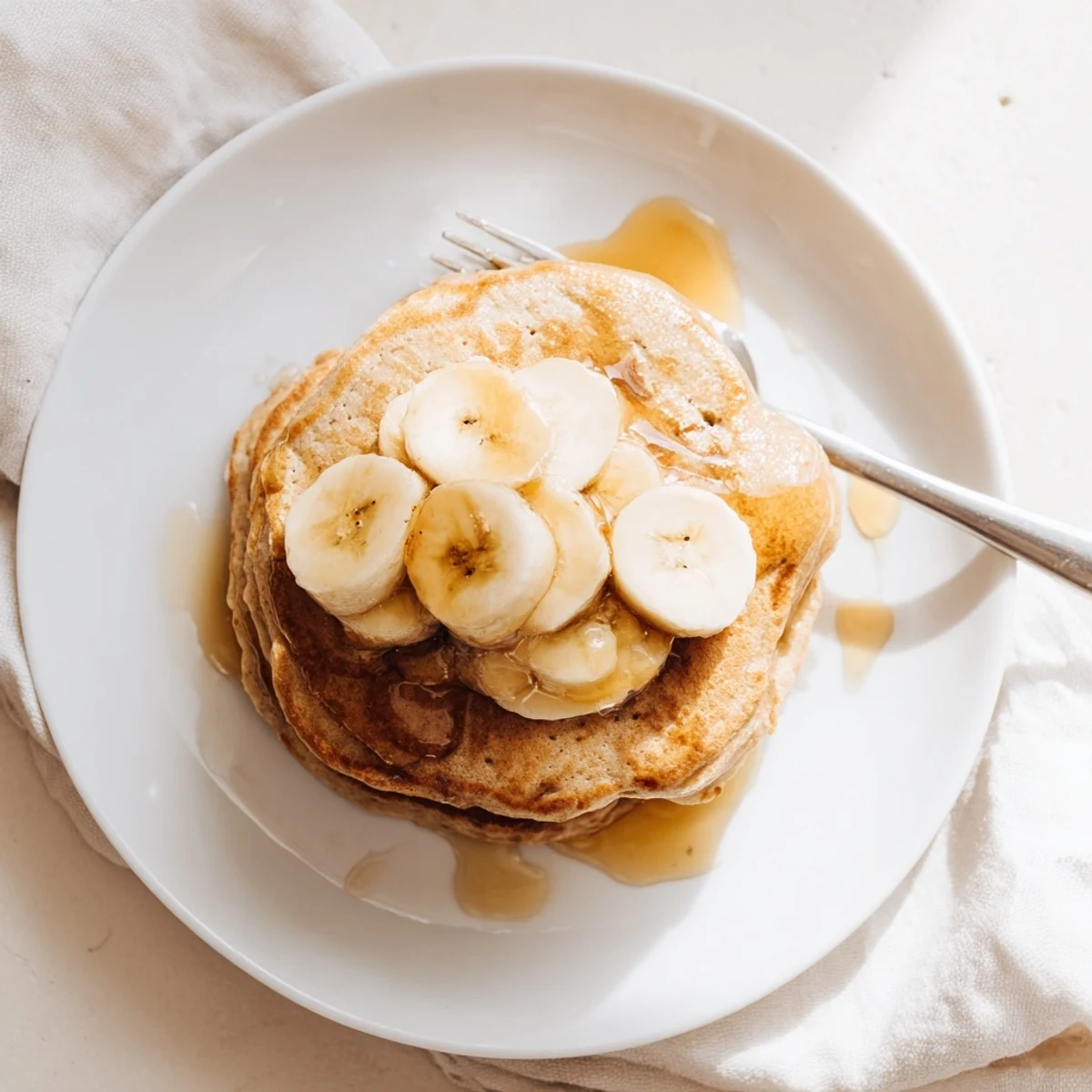 Protein-rich Greek yogurt banana pancakes topped with fresh banana slices and honey