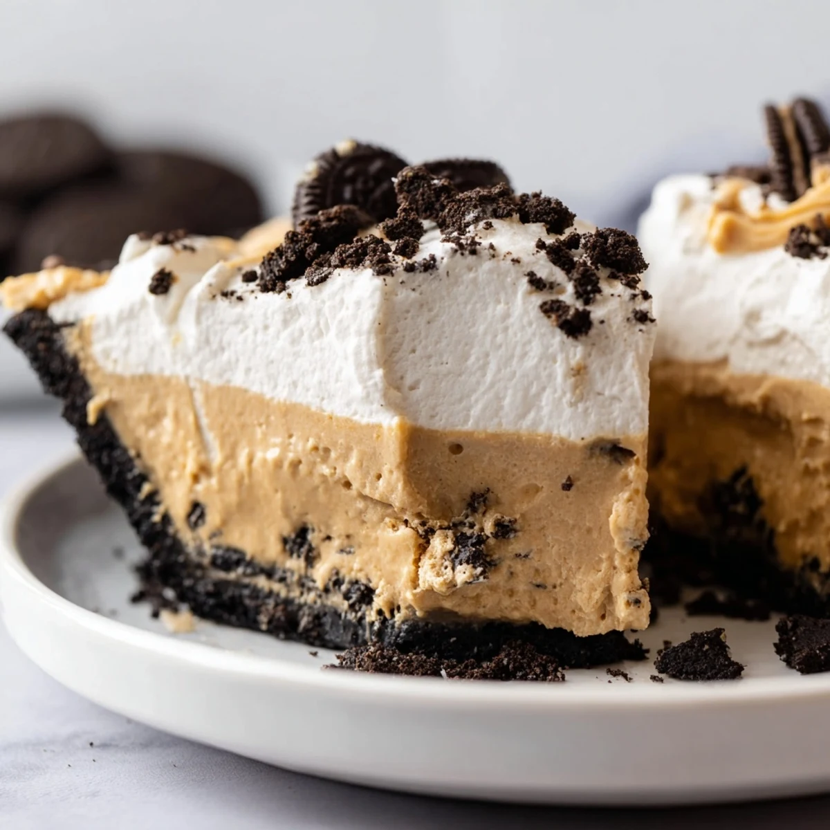 Silky peanut butter filling nestled in dark chocolate Oreo crust, ready to slice