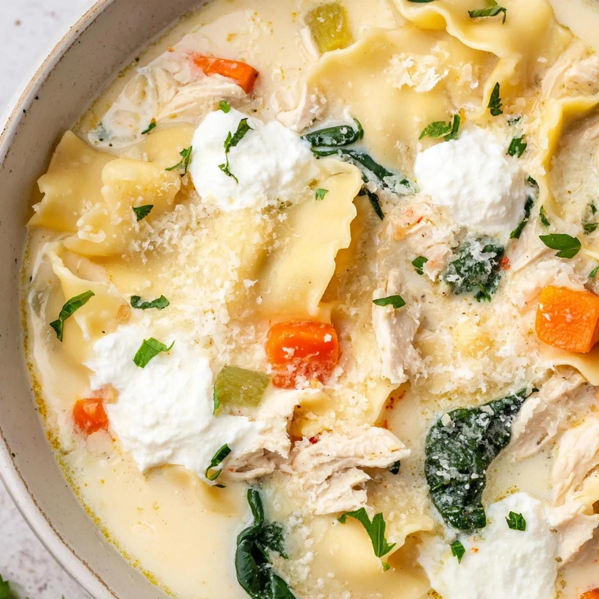 Creamy Italian white lasagna soup in a white bowl topped with fresh parsley and Parmesan cheese